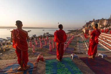 Varanasi, Hindistan - 18 Mar 2018: Genç hindu Rahipler şafak Ganj kıyısında karşılamak için bir tören yapmak ve Hint ve bayrağını yükseltmek. Varanasi Hinduizm 7 kutsal şehirlerden biri. 