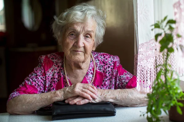 Bir Masada Oturan Yaşlı Bir Kadın Portresi — Stok fotoğraf