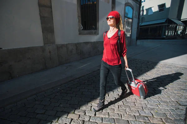 Chica Está Pavimento Con Una Maleta Roja — Foto de Stock