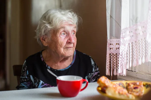Μια Ηλικιωμένη Γυναίκα Κοντά Στο Παράθυρο Ένα Φλιτζάνι Τσάι — Φωτογραφία Αρχείου