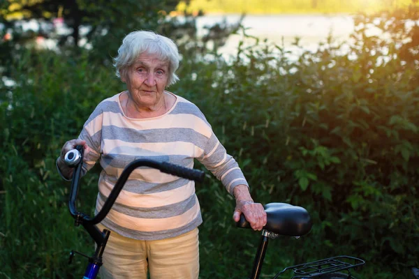 Een Oudere Vrouw Staat Met Een Fiets — Stockfoto