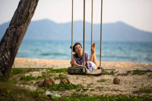 亚洲年轻女子躺在海边的秋千上 — 图库照片