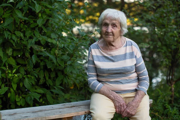 Een Bejaarde Vrouw Zitten Een Houten Bankje Het Park — Stockfoto