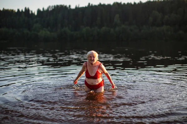 Yaşlı Kadın Banyoları Nehre Günbatımında Sıçramasına — Stok fotoğraf