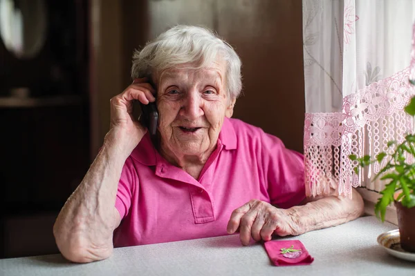 Una Anciana Hablando Por Teléfono Sentada Mesa — Foto de Stock