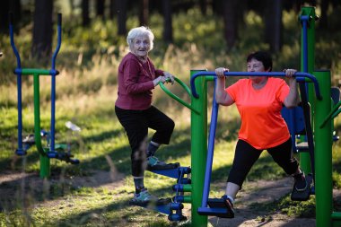 Yaşlı kadın parkta spor Bahçesi egzersizleri yapıyor.