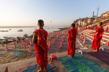 Varanasi, Hindistan - 18 Mar 2018: Genç hindu Rahipler şafak Ganj kıyısında karşılamak için bir tören yapmak ve Hint ve bayrağını yükseltmek. Varanasi Hinduizm 7 kutsal şehirlerden biri. 