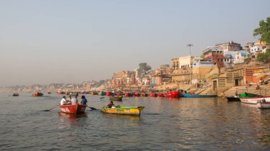 Varanasi, Hindistan - 26 Mar 2018: Bir tekne görünümünden suda Varanasi kıyı boyunca Ganj Nehri üzerinde süzülüyor. Efsaneye göre şehrin yaklaşık 5000 yıl önce Tanrı Shiva tarafından kuruldu.