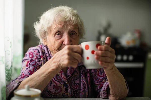 Una Donna Anziana Che Beve Seduta Cucina — Foto Stock