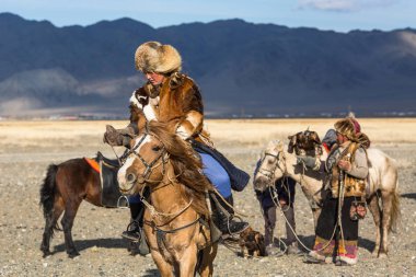 Sagsay, Moğolistan - 28 Eylül 2017: Kartal avcı kuşları ile tavşan içinde çöl Dağ Batı Moğolistan için avcılık genç kızı öğretir..
