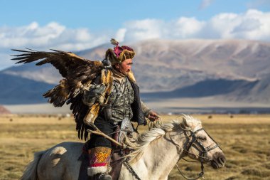 Sagsay, Moğolistan - 28 Eylül 2017: Altın Kartal avcı ise bir Altın Kartallar kollarını içinde çöl Dağ Batı Moğolistan üzerinde tutarak tavşan için avcılık.