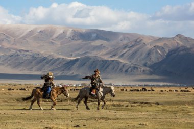 Sagsay, Moğolistan - 28 Eylül 2017: Kartal avcı kuşları ile tavşan içinde çöl Dağ Batı Moğolistan için avcılık genç kızı öğretir..