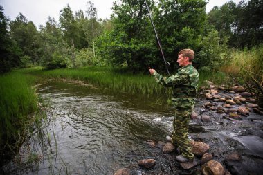  Nehirde balık yakalamak taşlar üzerinde duran balıkçı.