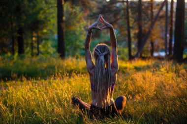 Yeşil bir ormandaki pitoresk bir glade kadını Yoga.