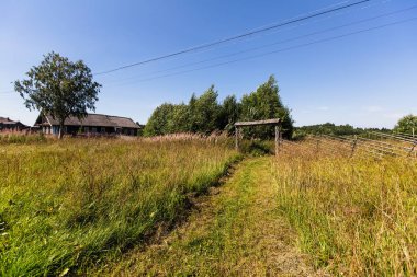 Kırsal manzara, ahşap evler, alan ve çit twigs yaptı.
