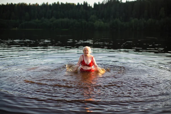 Gün Batımında Yaz Nehirdeki Yaşlı Kadın Sıçraması — Stok fotoğraf