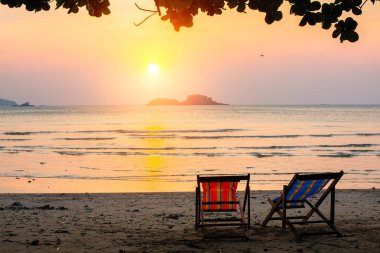 Şaşırtıcı günbatımı, deniz kenarında şezlong.