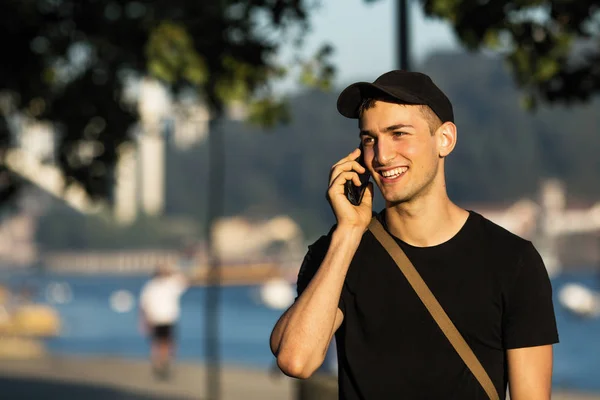 Young man talking on the phone in the street.