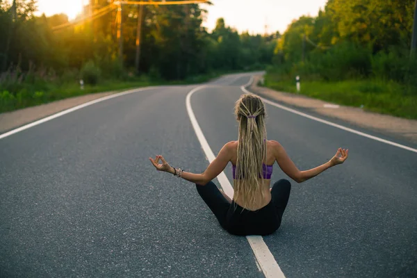 Женщина Йога Медитирует Сидя Посреди Сельской Дороги — стоковое фото