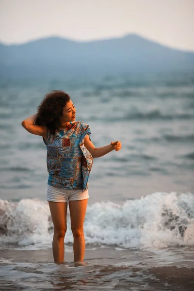 すばらしい夕日の光の中で熱帯のビーチで若い混血女性 — ストック写真