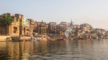 Varanasi, Hindistan - 26 Mar 2018: Bir tekne görünümünden suda Varanasi kıyı boyunca Ganj Nehri üzerinde süzülüyor. Efsaneye göre şehrin yaklaşık 5000 yıl önce Tanrı Shiva tarafından kuruldu.