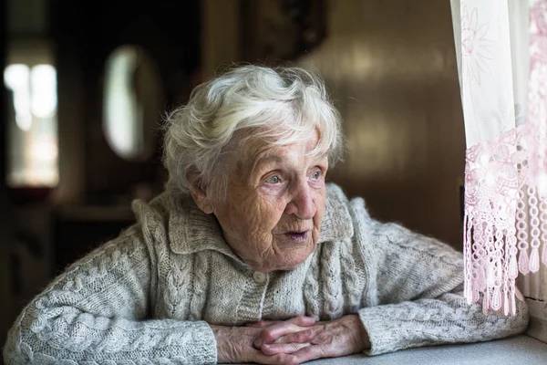 Gråhårig Äldre Kvinna Ser Genom Fönstret — Stockfoto
