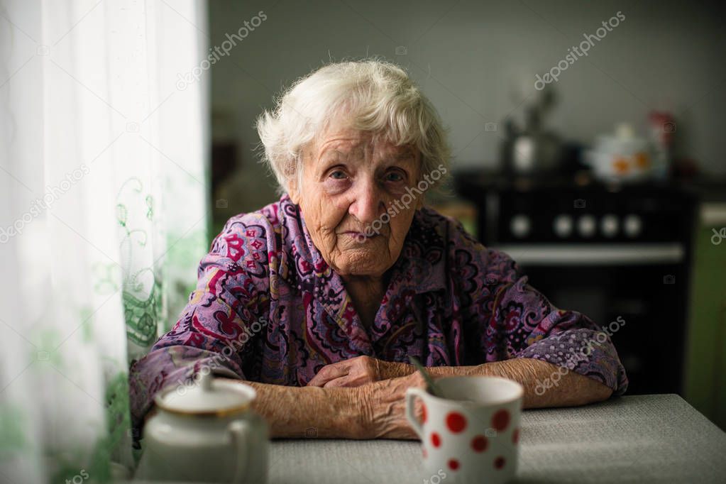 Portrait of an elderly woman sitting at the table.