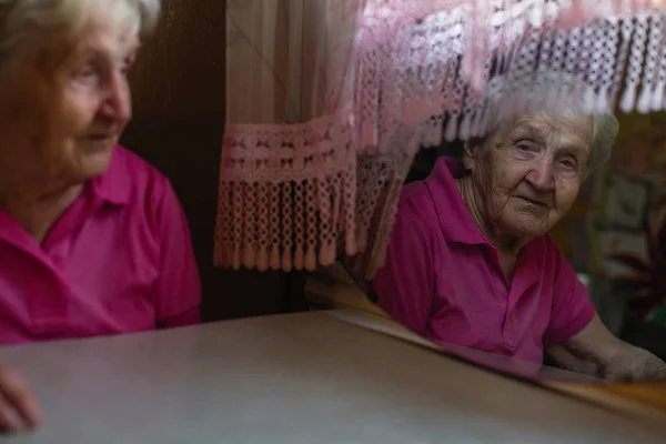 Пожилая Женщина Смотрит Сквозь Отражение Зеркале — стоковое фото