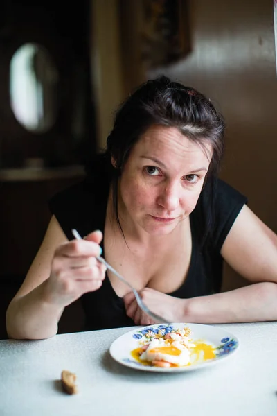 Kobieta Siedzi Przy Stole Domu Jedzenie Jajecznicy — Zdjęcie stockowe