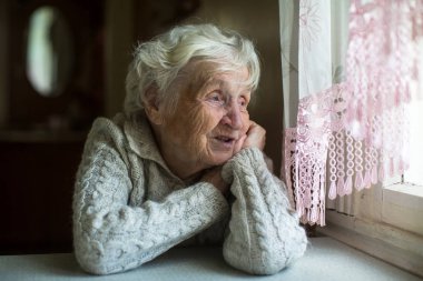 Yaşlı Bayan pencereden görünüyor.