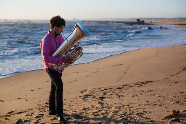 海の海岸に チューバを演奏若い音楽家 — ストック写真