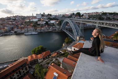 Kadın Dom ben köprü, Luis Douro nehir, Porto, Portekiz karşısında görüntüleme platformu üzerinde dreadlocks ile.