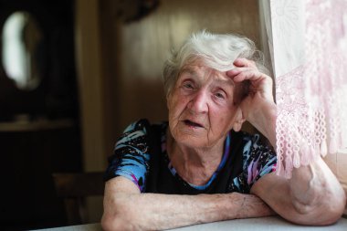 Masada oturan evinin mutfakta yaşlı kadın.