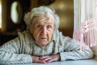 Gri saçlı yaşlı kadın portre, pencerenin oturan.