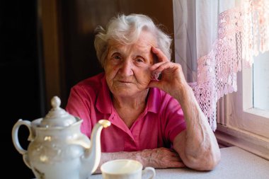 masada oturan yaşlı kadın portresi.