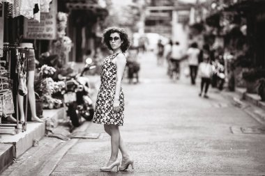 Genç Asyalı kadın Bangkok sokakta duruyor.