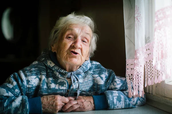 テーブルの家に高齢者の女性の肖像画 — ストック写真
