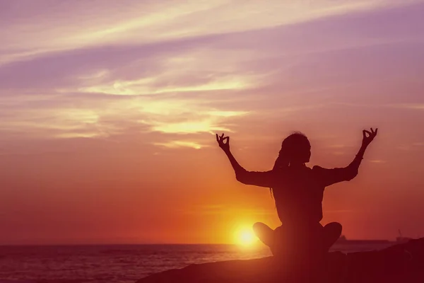 日落时分在海边沉思的女子瑜伽剪影 — 图库照片
