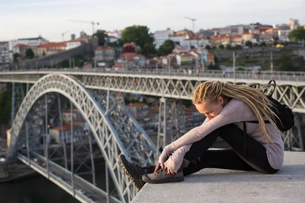 Dreadlocks blondy woman on viewing platform opposite Dom Luis I bridge in Porto - Portugal.