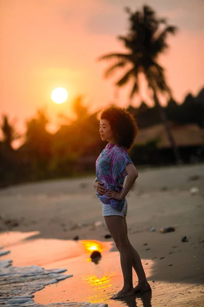 在热带海滩上的混合种族妇女在惊人的日落 — 图库照片