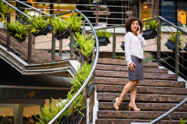 亚洲妇女站在户外的台阶上打电话 — 图库照片