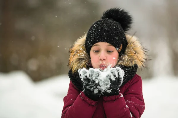 驚くべき冬の手で雪の上吹く少女 — ストック写真