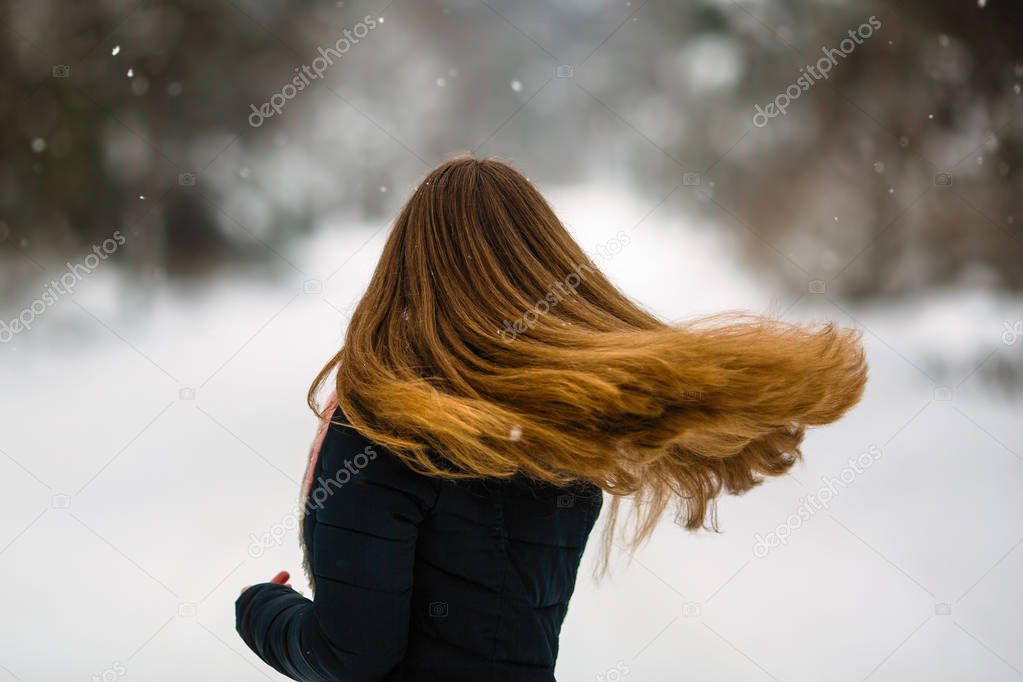 Girl's long hair. Fluttering beautiful hair of young woman in winter outdoors.  