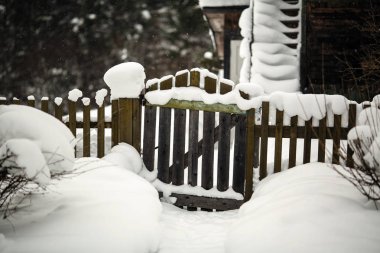 Ahşap çit ve kapı evin yanında. Rus köy sokakta karlı kış.