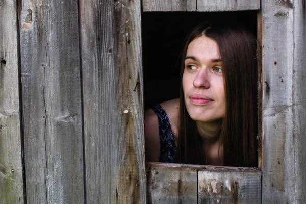 Junge Frau Blickt Aus Den Holzschuppenfenstern — Stockfoto