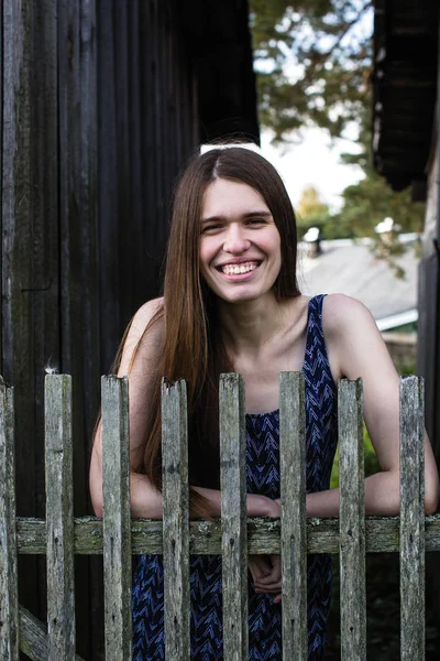 Ahşap çitler yakınındaki uzun saçlı genç komik kadın portre.