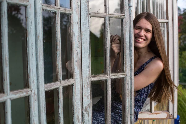 Neşeli Genç Kadın Uzun Saçlı Kırsal Pencereden Görünüyor — Stok fotoğraf
