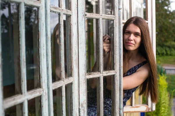 Frau Mit Langen Haaren Schaut Aus Dem Fenster Der Veranda — Stockfoto