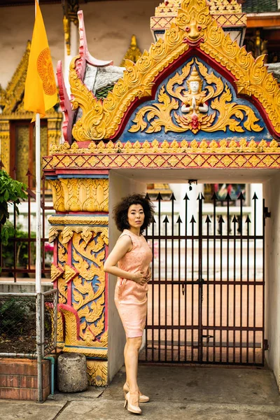 一个年轻的亚洲女人站在一座佛教寺庙的门口 — 图库照片