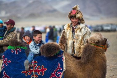Sagsay, Moğolistan - Eyl 30, 2017: Yerel kazak erkek çocuk bir deve üzerinde yerel bir tatil sırasında rides. 